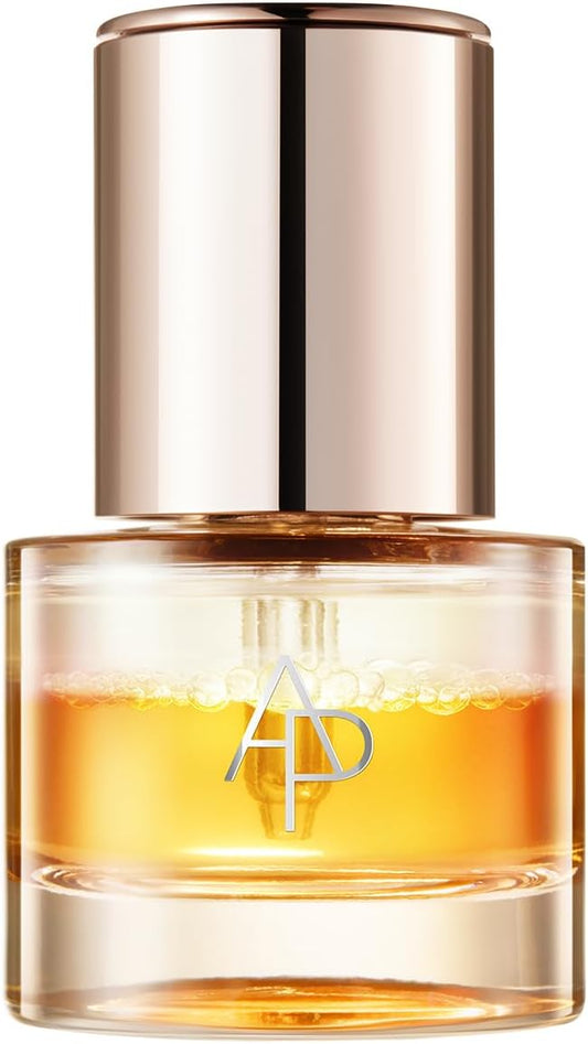 A clear glass bottle of amber-colored liquid with a reflective metallic rose gold cap, featuring a silver 'AD' logo on the front.