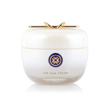 White jar of 'The Silk Cream' with a gold lid on a white background