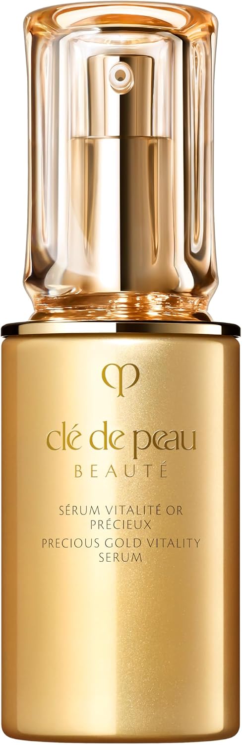Clé de Peau Beauté Precious Gold Vitality Serum in a gold bottle with a clear cap and gold pump, on a white background.
