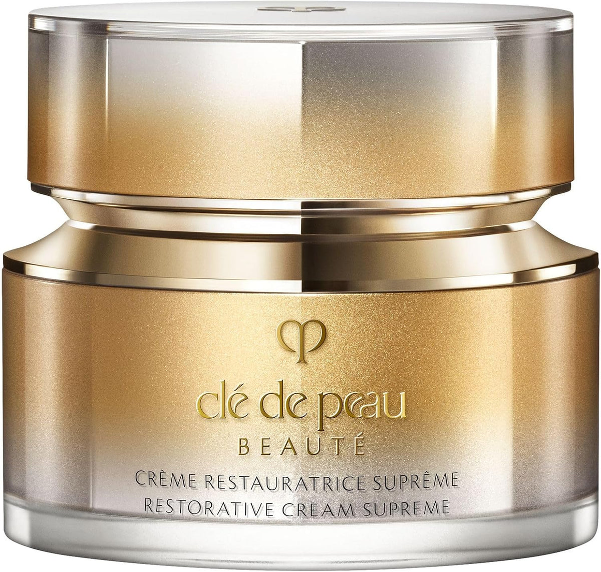 A jar of de de peau Beauté Crème Restauratrice Suprème, featuring a metallic gold and silver gradient jar with a matching metallic lid, set against a clean white background.